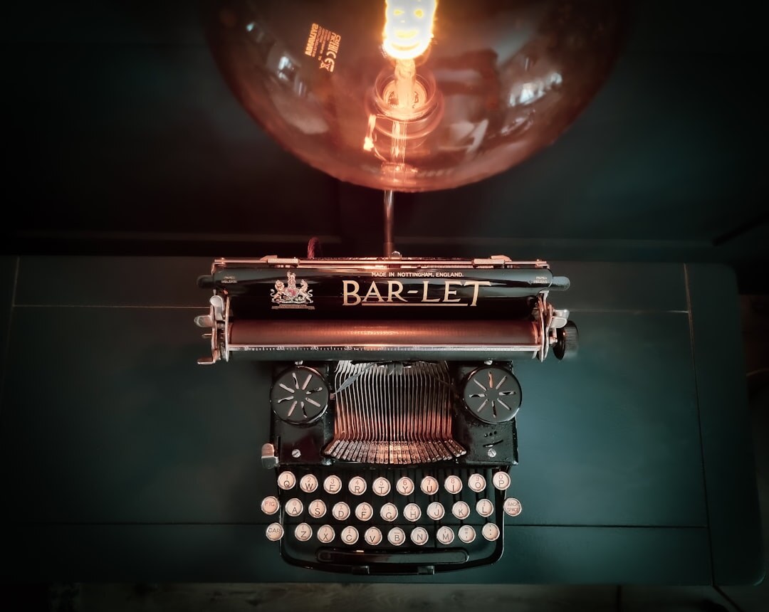 Close-up of a vintage typewriter and notebook on a wooden desk